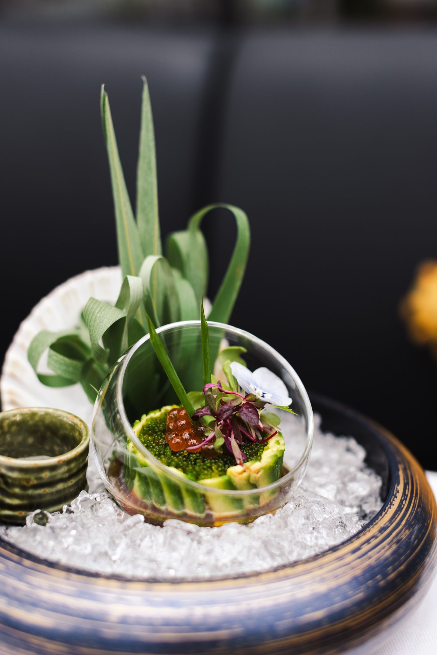 Avocado and tobiko served on ice in a glass bowl