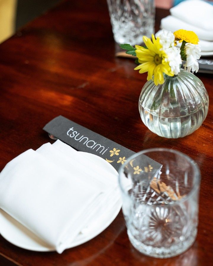 A set table with flowers and a Tsunami napkin, from Instagram