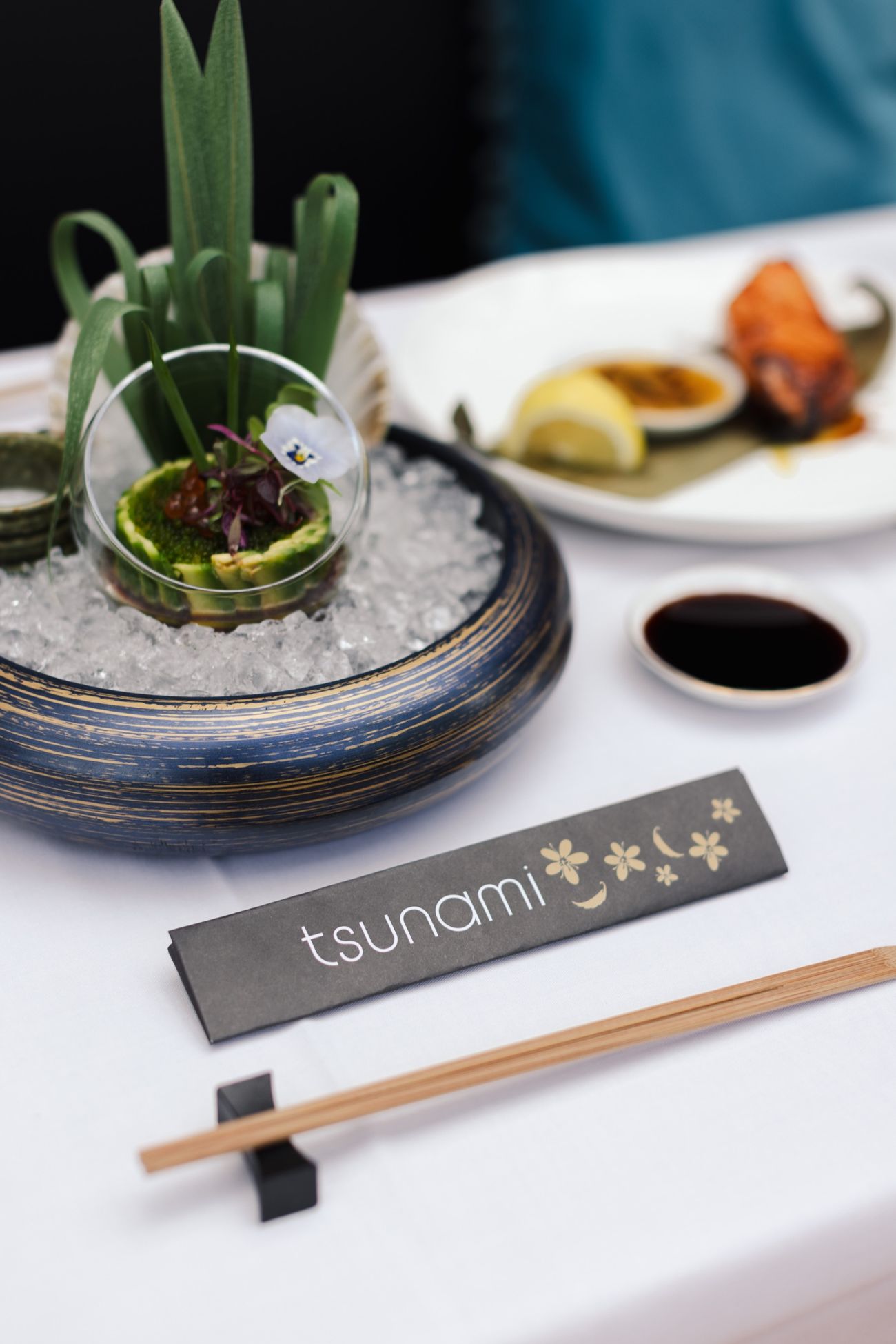 A Tsunami table set with chopsticks and a chopstick wrap